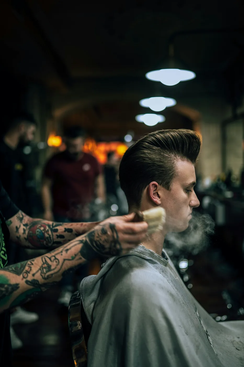 A barber working with a customer in a barbershop